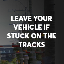 Leave your vehicle if stuck on the tracks